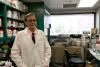 A photo of chemistry professor Mark Lovell in a lab coat in his lab. 