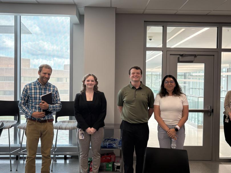 Poster award winners stand with Dr. Graham